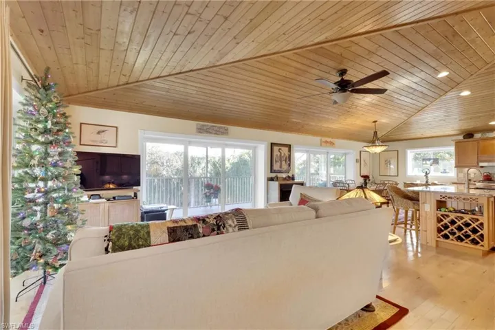 Living area featuring wood ceiling, light wood-style floors, ceiling fan, and vaulted ceiling