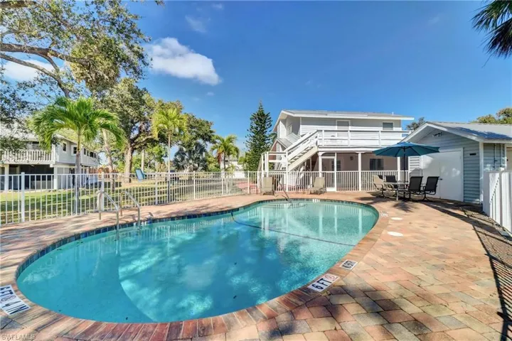 Community pool with a patio, stairway, and outdoor dining space