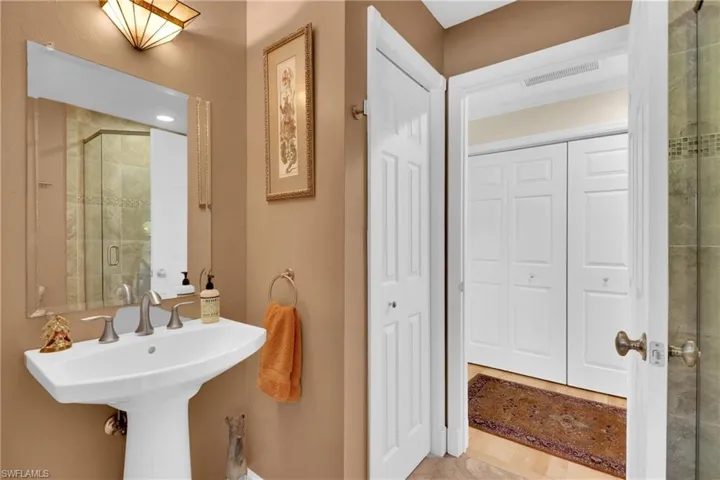 Bathroom featuring a stall shower and a closet