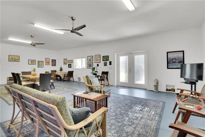 Great Room with french doors, concrete floors, and a ceiling fan