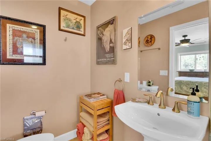 Half bathroom featuring a ceiling fan and ensuite bathroom