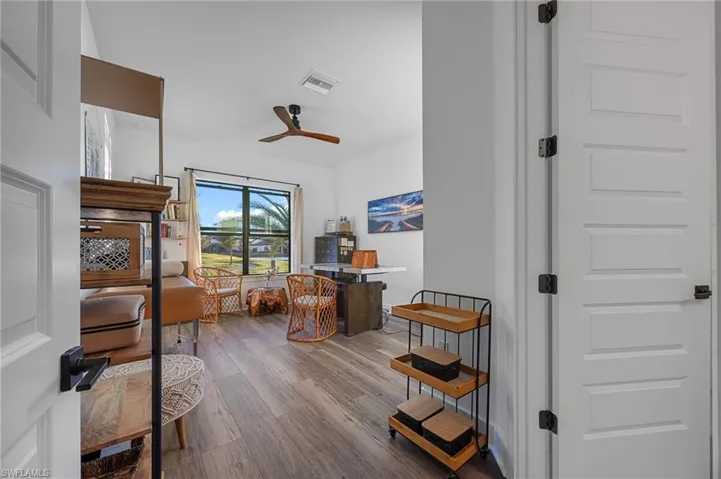 Bedroom featuring wood finished floors, a ceiling fan, a closet, and ensuite bathroom