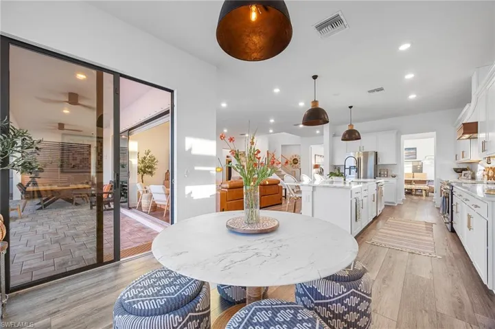 Dining area with recessed lighting and light wood-type flooring