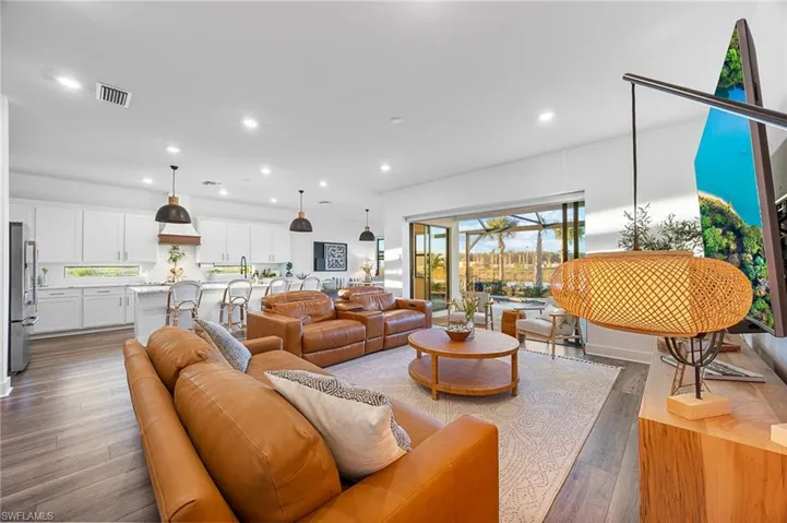 Living area featuring dark wood-type flooring and recessed lighting
