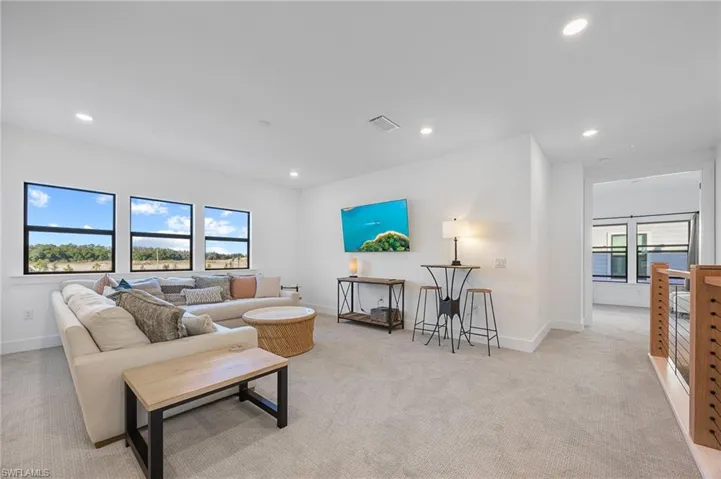 Living room featuring light colored carpet and recessed lighting