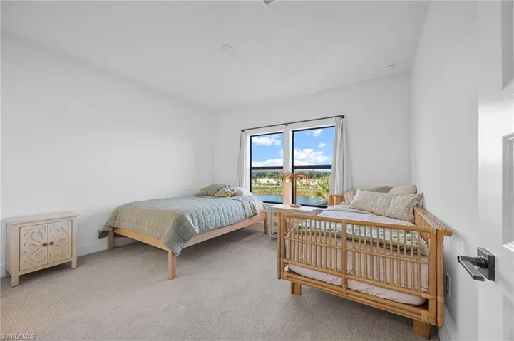 Bedroom featuring light carpet and a water view
