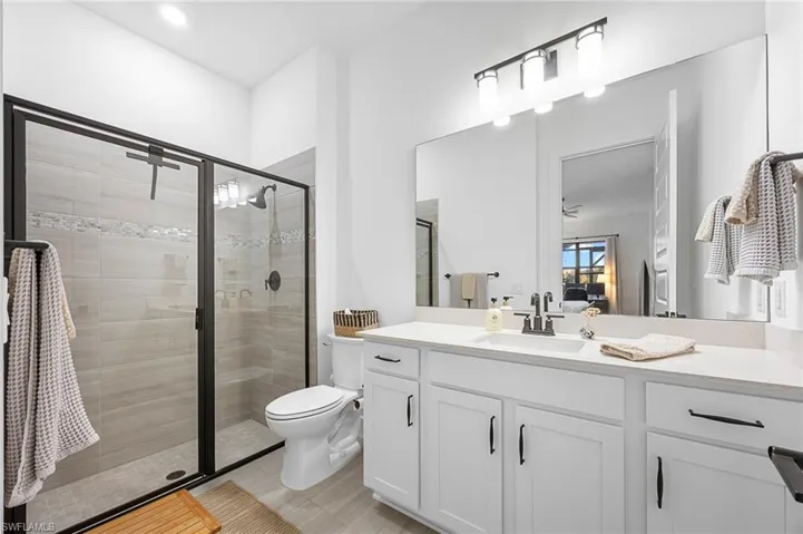 Bathroom featuring vanity, a stall shower, and connected bathroom