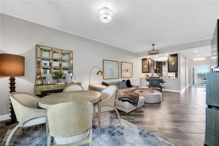 Open-concept living area with tile flooring and crown molding