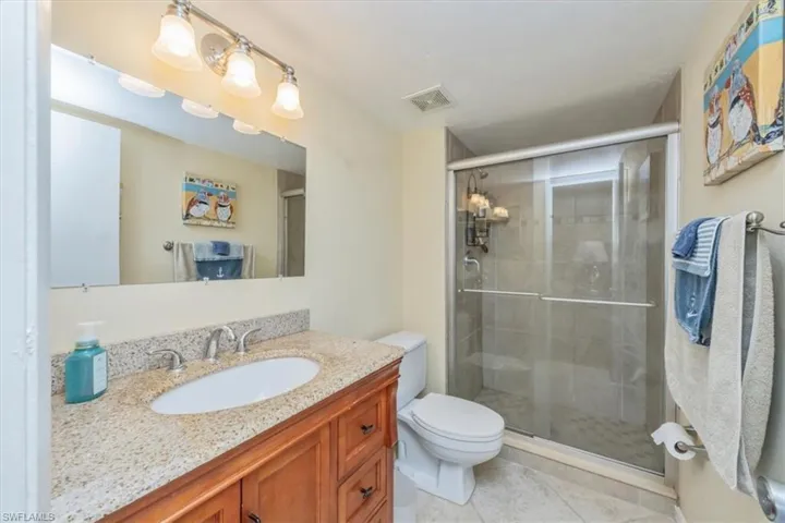 Full bath with vanity, a stall shower, and light tile patterned floors