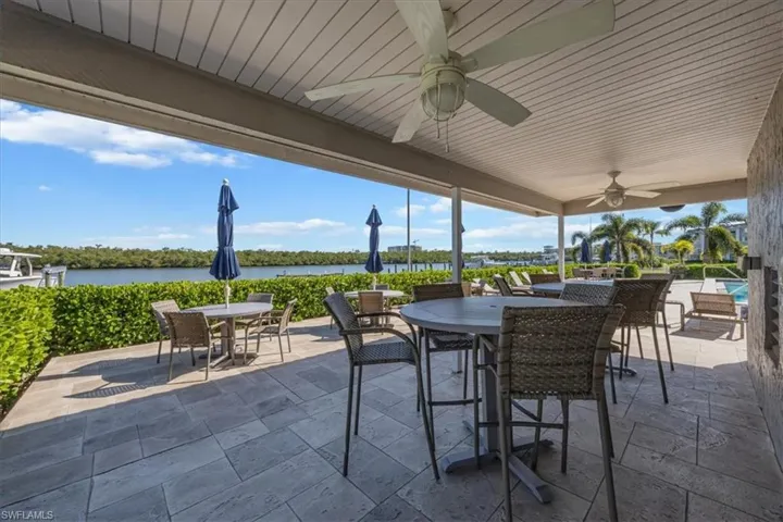 View of Mariners Cove patio featuring a water view, outdoor dining area, and ceiling fan