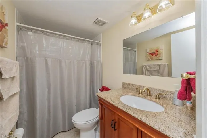 Bathroom featuring vanity, a shower with shower curtain, and light tile patterned floors