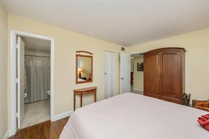 Bedroom with wood finished floors, a closet, and ensuite bath