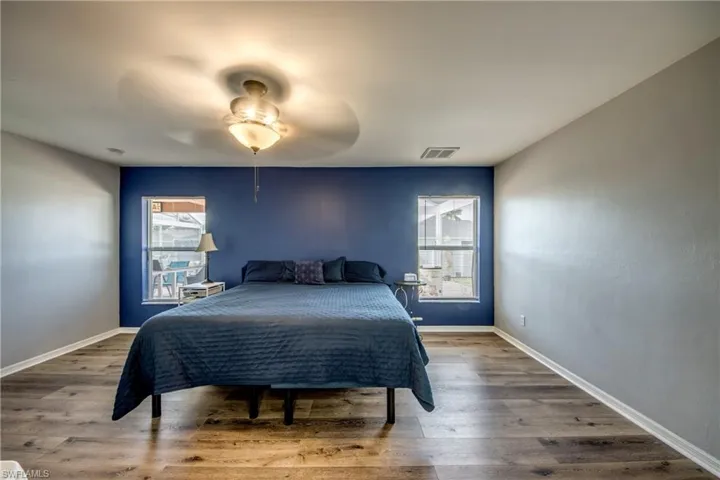 Bedroom with wood finished floors, baseboards, and ceiling fan