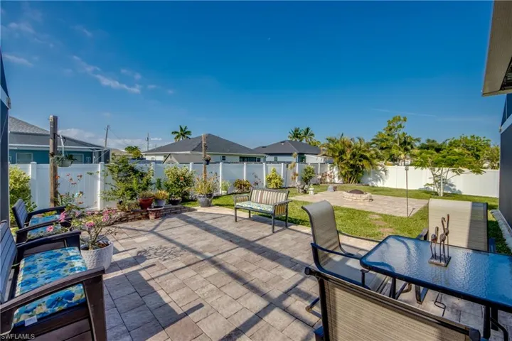 Fenced backyard featuring a patio area, outdoor dining space, and a fire pit