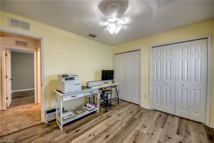 Office area with ceiling fan, wood finished floors, and baseboards