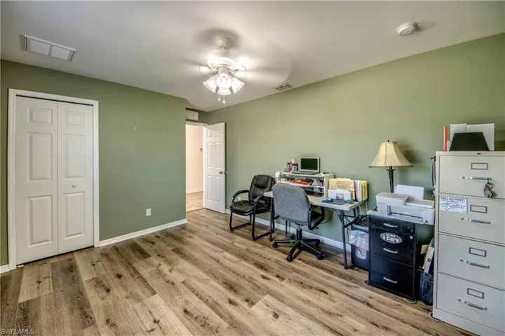 Office area with wood finished floors, baseboards, and ceiling fan