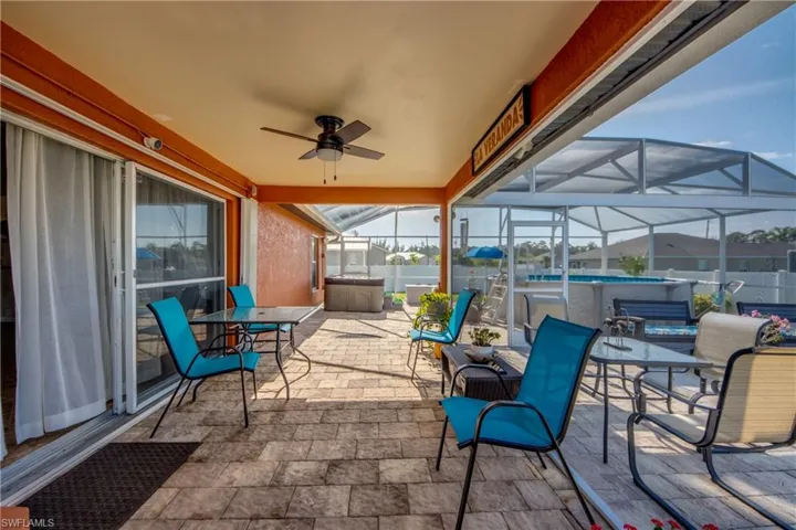 View of patio / terrace with ceiling fan, a lanai, an outdoor pool, a jacuzzi, and outdoor dining area
