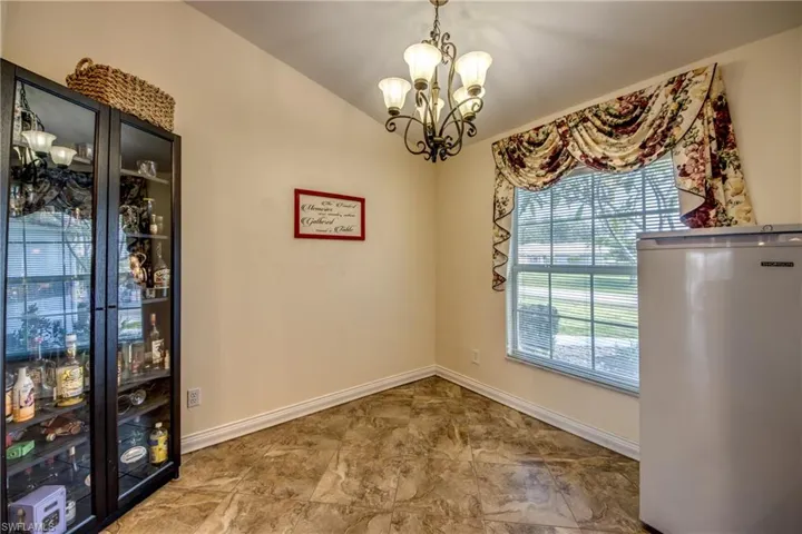 Unfurnished dining area featuring a chandelier and baseboards