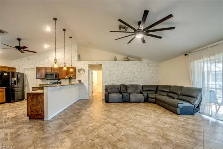 Living room with ceiling fan and high vaulted ceiling