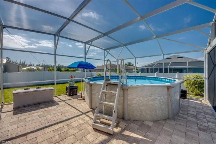 Fenced backyard featuring glass enclosure and a patio area