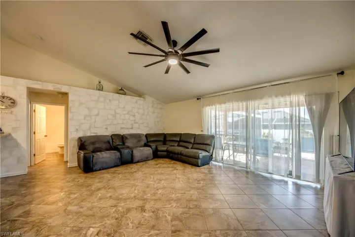 Living room featuring a ceiling fan and lofted ceiling