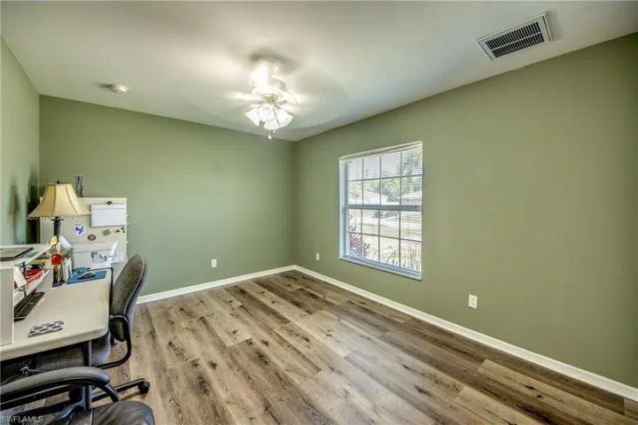 Office area with wood finished floors, baseboards, and a ceiling fan