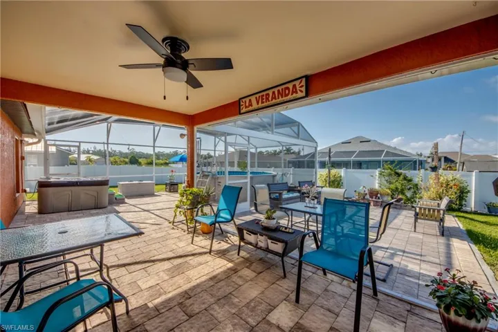 Fenced backyard featuring a hot tub, a patio area, and glass enclosure