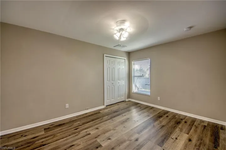 Spare room with baseboards, wood finished floors, and a smoke detector