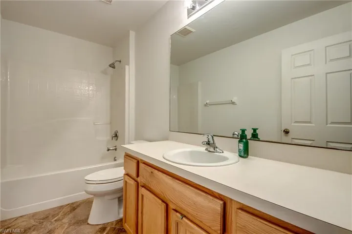 Full bathroom with toilet, vanity, and washtub / shower combination