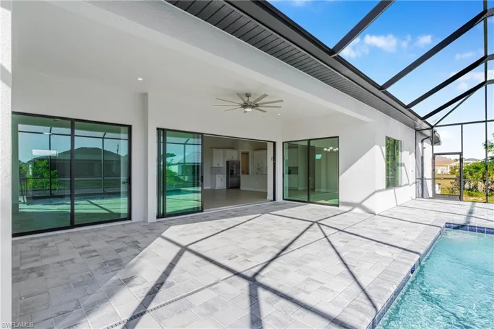 View of patio with a sunroom, a ceiling fan, a lanai, and an outdoor pool