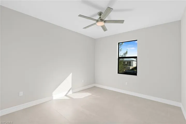 Spare room with ceiling fan and light tile patterned floors