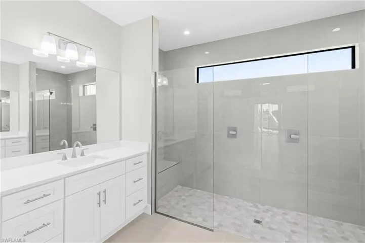 Full bath with vanity, a walk in shower, light tile patterned flooring, and recessed lighting