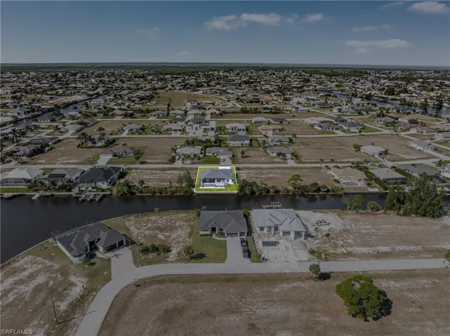 Aerial view of property's location with nearby suburban area and a large body of water