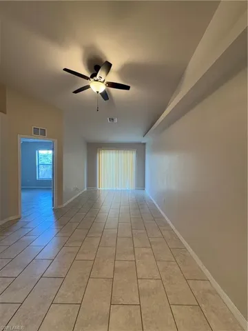 Tiled empty room featuring ceiling fan