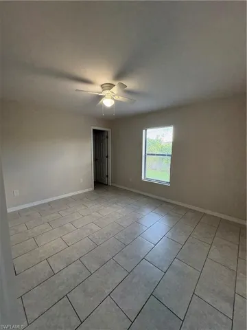 Spare room with ceiling fan and light tile patterned floors
