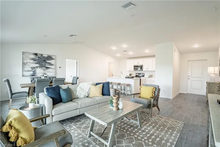 Living room with vaulted ceiling and dark wood-type flooring