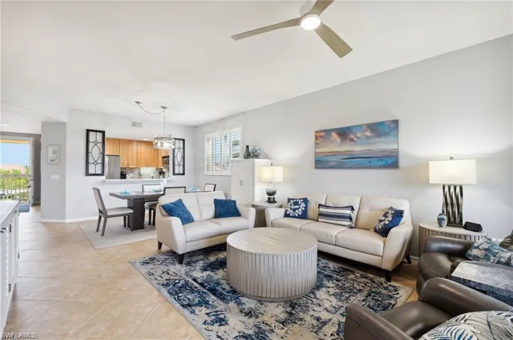 Living room with light tile patterned flooring and ceiling fan