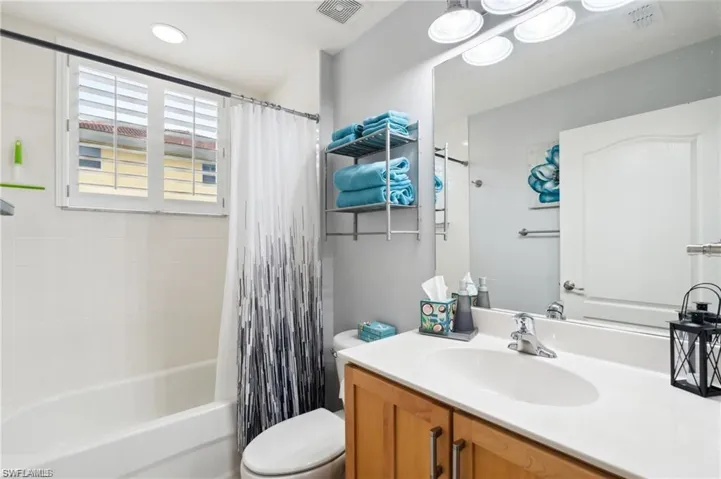 Full bath featuring vanity and shower / bath combination with curtain
