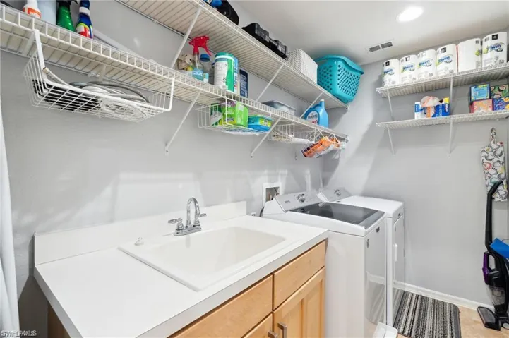 Laundry area featuring washer and clothes dryer and a sink