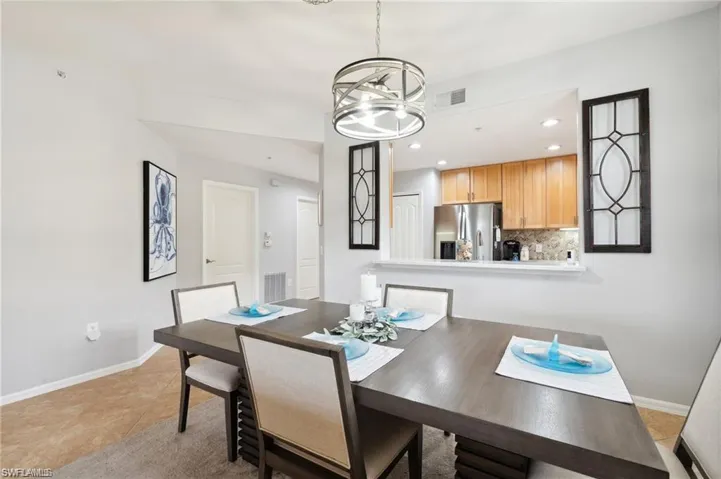 Dining space featuring recessed lighting, light tile patterned flooring, and a chandelier