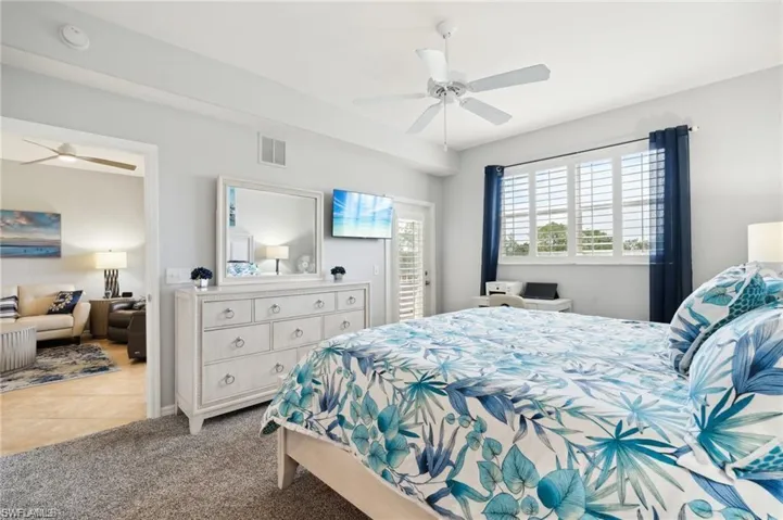 Carpeted bedroom featuring ceiling fan and tile patterned flooring