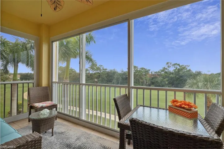 Sunroom featuring golf course view, tile patterned floors, and view of scattered trees