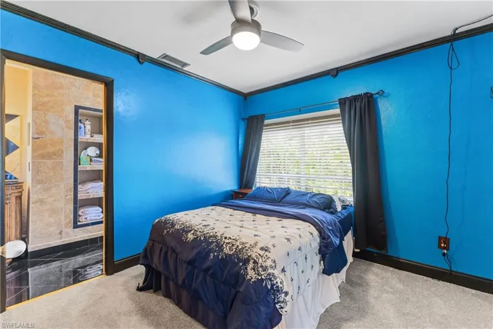 Bedroom with carpet, ornamental molding, and ceiling fan