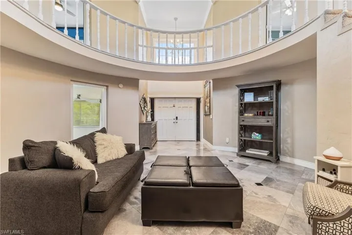 Living room with ceiling fan and a high ceiling
