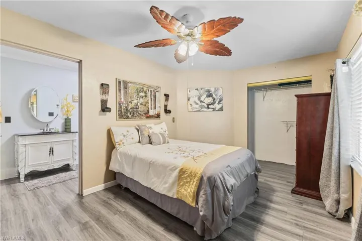 Bedroom featuring ceiling fan, hardwood / wood-style floors, a closet, and sink