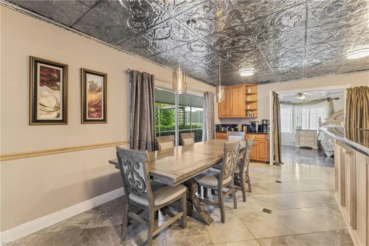 Tiled dining room with ceiling fan and a wealth of natural light