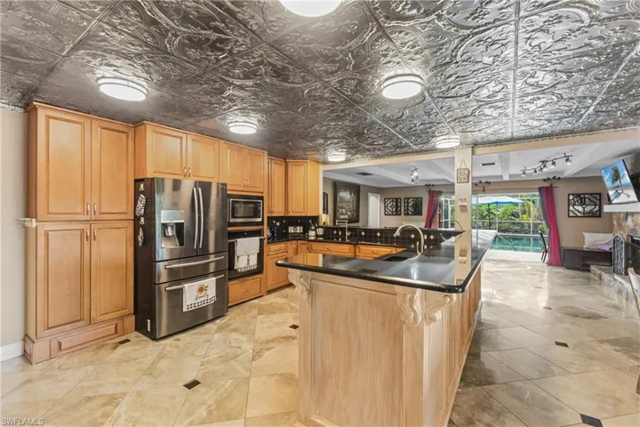 Kitchen featuring a kitchen bar, stainless steel appliances, sink, kitchen peninsula, and rail lighting
