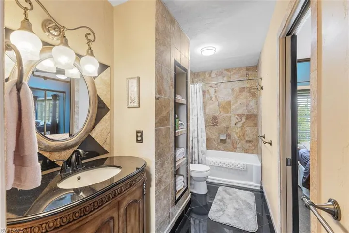 Full bathroom featuring shower / bath combo, tile patterned flooring, toilet, and vanity