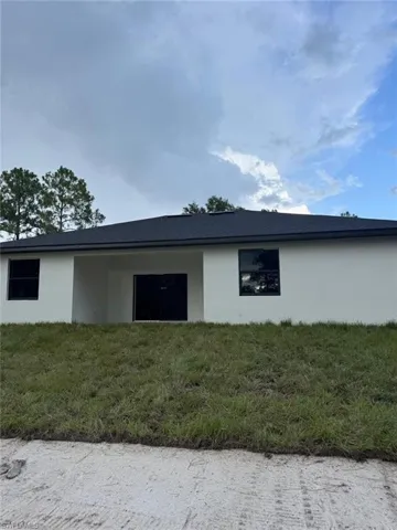 View of property exterior with stucco siding and a yard