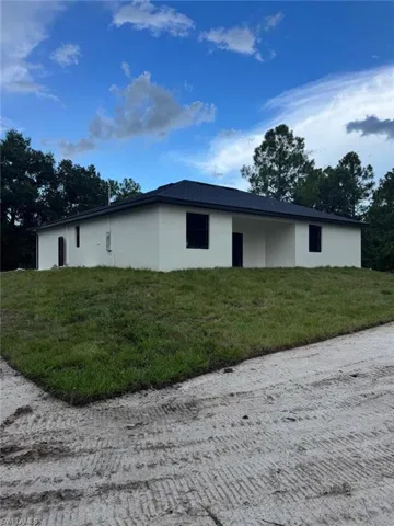 View of home's exterior with stucco siding and a lawn